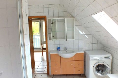 Ferienwohnung Nordsee-Weltblick Innenfoto Badezimmer mit Waschmaschine und voll ausgerüsteten Badelement