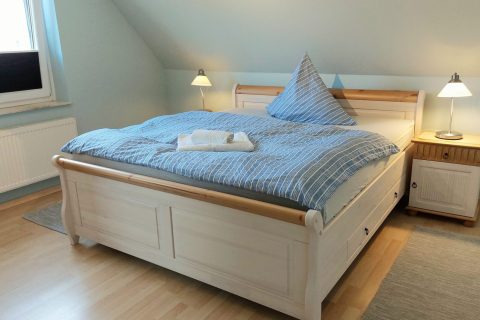 Ferienwohnung Nordsee-Weltblick Innenfoto gemütliches Schlafzimmer mit Hochbett und Schlafzimmerschrank